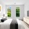 large bedroom with king bed and bright lighting from windows