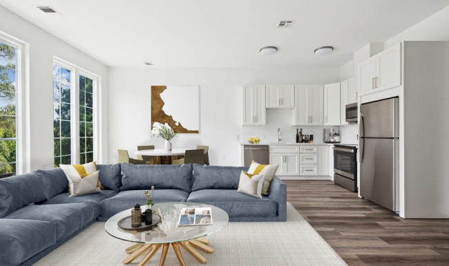 spacious living room with large sectional next to dining table and kitchen